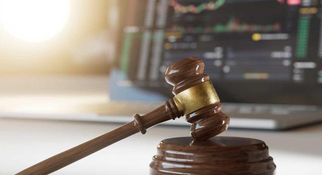 El Tribunal Supremo puntualiza su doctrina en materia sancionadora respecto a rendimientos procedentes de las operaciones simuladas imputadas al socio o participe y su conexión con el derecho de presunción de inocencia. Imagen de un mazo de juez al lado de un ordenador con gráficos en su pantalla