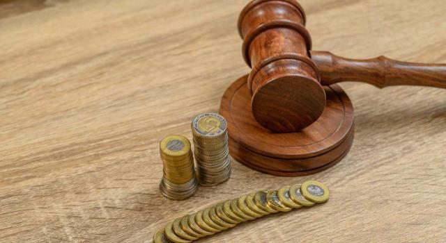 El TS de be determinar si se aplica la regla especial del art. 37.1.g) Ley IRPF a la totalidad de la indemnización percibida como compensación del daño sufrido en un inmueble por la restricción de su derecho a la edificabilidad. Imagen de un mazo de juez junto a montones de monedas