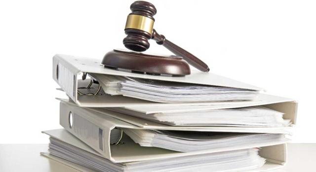 Selección de doctrina administrativa. Febrero 2026 (2.ª quincena). Imagen de un mazo de juez sobre tres archivadores de trabajo