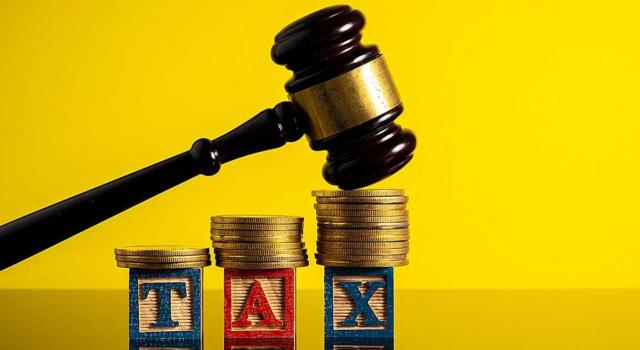 La regularización de bienes de inversión no puede aplicarse retroactivamente para alterar actos firmes derivados de simulación subjetiva, aunque posteriormente se haya realizado un cambio societario. Imagen de un mazo aporreando un monton de monedas y la palabra tax