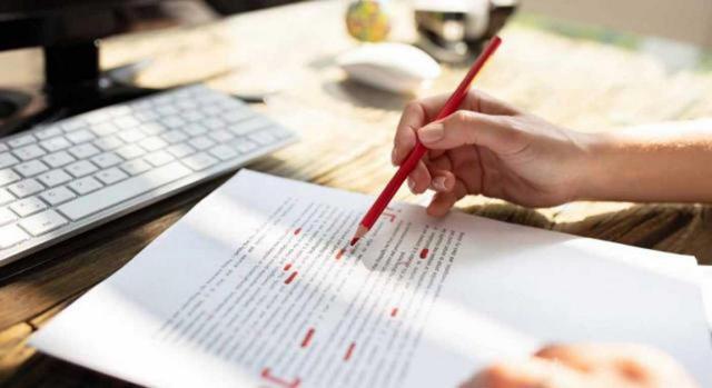 medidas fiscales rioja. Imagen de una persona corrigiendo el texto de un documento con un lápiz rojo