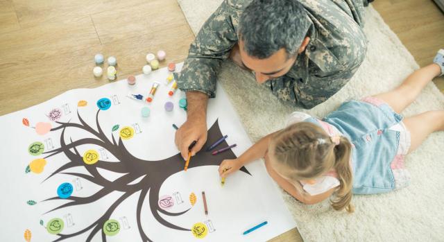 Medidas Galicia. Imagen de un padre e hija tumbados en el suelo y pintando