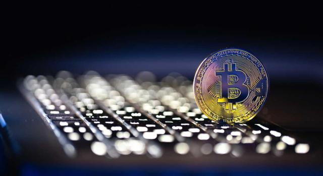 Bizkaia adapta su normativa tributaria a la DAC 8 e incorpora nuevas obligaciones sobre criptoactivos Bizkaia adapta su normativa tributaria a la DAC 8 e incorpora nuevas obligaciones sobre criptoactivos. Imagen de una moneda virtual bitcoin encima de escritorio de portatil