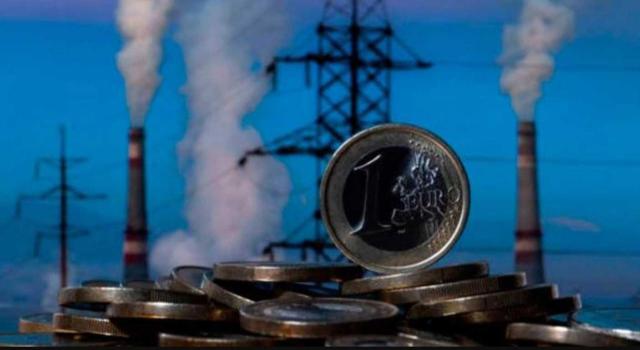 El TS deberá pronunciarse sobre el efecto directo de la exención en el Impuesto al Carbón del art. 14.1.a) de la Directiva 2003/96/CE en relación con carbón utilizado para generación eléctrica y si caben excepciones por motivos medioambientales. Imagen de unas montaña de monedas y por detrás, la chimenea de una industria y una torre de la luz