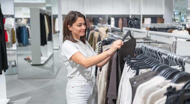 El TJUE resuelve las cuestiones prejudiciales en materia de aduanas del Grupo Massimo Dutti referidas al valor de las mercancías en aduanas cuando existen ventas sucesivas. Imagen de una mujer comprando en una tienda