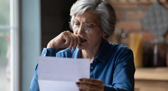 Tributación en IRPF de una indemnización percibida en un procedimiento expropiatorio en compensación por una ilegítima expropiación. Imagen de una señora con cara de preocupación mirando un papel