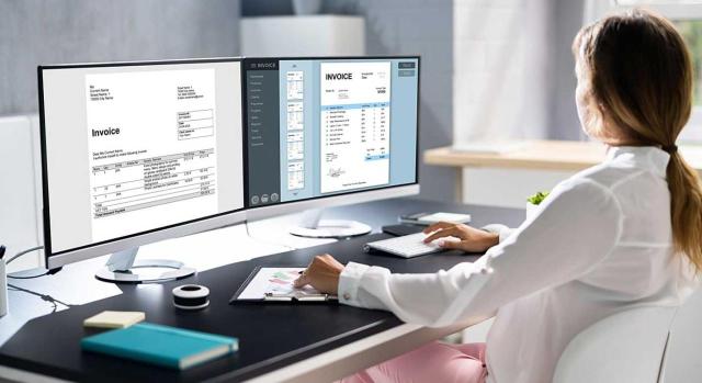 Asesora fiscal/laboral que usa Word y Excel para emitir facturas, pregunta a la DGT sobre su obligación de aplicar el Reglamento Veri*Factu y si puede considerarse un “programa de doble uso” a efectos de infracciones. Imagen de una chica trabajando con doble pantalla