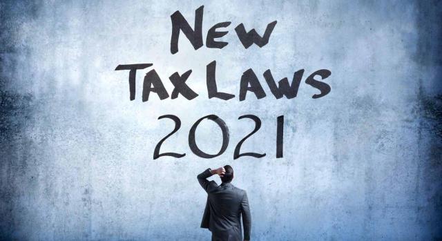 Novedades impuestos 2021​. Hombre desconcertado frente a una pared que pone "New Taxs Laws 2021"