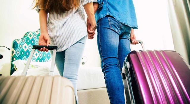 IVA: vivienda nueva arrendada a sociedad para alojamiento turístico Arrendar una vivienda nueva a una sociedad para que la destine a alojamiento turístico es una operación sujeta a IVA con derecho a deducción si está afecta a actividad empresarial. Imagen de una pareja de espaldas con una maleta de viaje cada uno