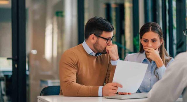 Matrimonio vs pareja de hecho en la Renta: diferencias en el IRPF y cómo afectan a tu tributación. Imagen de una pareja echando cuentas con cara de preocupación