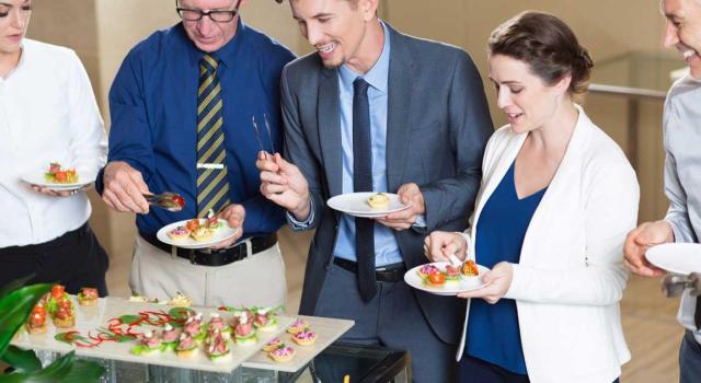 Para deducir las cuotas de IVA correspondientes a atenciones a clientes no basta con la expectativa de mejorar los resultados empresariales. Imagen de unas personas comiendo algo de un catering