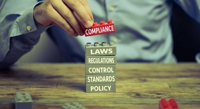 Tax compliance: qué es y cómo ayuda a la gestión del riesgo fiscal. Imagen de un hombre haciendo una torre con piezas de lego en las que en cada una viene una palabra sobre incumplimiento