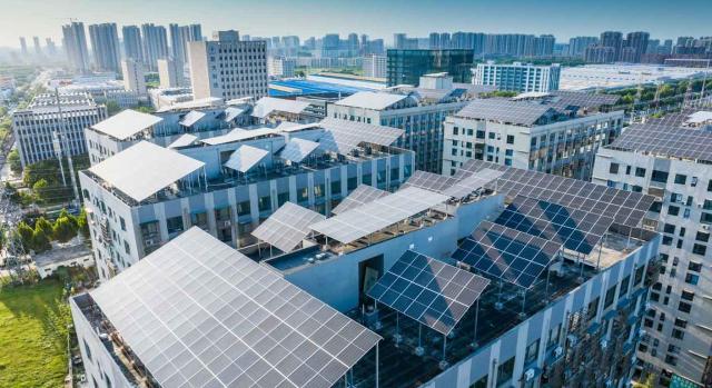 Deducción del 40% en IRPF por instalar placas solares por comunidad de propietarios. Paneles solares en el tejado de una ciudad moderna