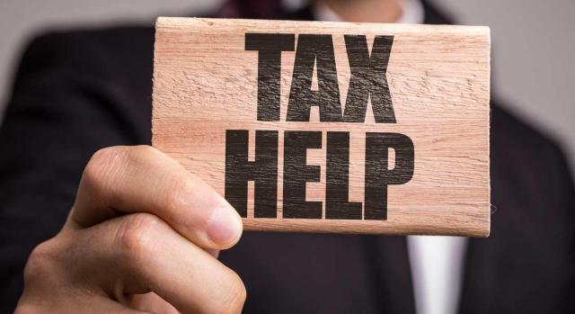 Plan de control tributario 2021. Imagen de hombre sujeanto en la mano un cartel donde pone tax help