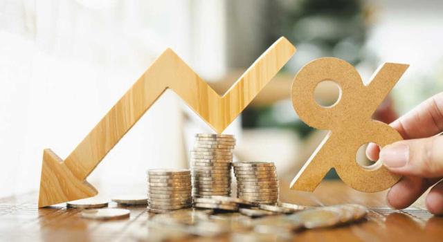 Análisis del tipo reducido del IS para entidades de nueva creación ante la existencia de entidades vinculadas y socios personas físicas Tipo reducido del 15% en IS para entidades de nueva creación ante la existencia de entidades vinculadas y socios personas físicas. Imagen de una mesa con monedas en la que se ve un porcentaje y una flecha hacia abajo