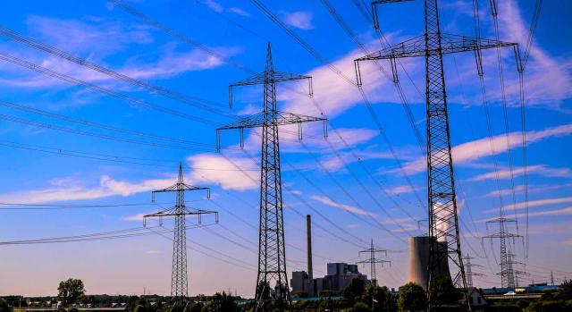 Bizkaia modifica el modelo 591: Impuesto sobre el Valor de la Producción de la Energía Eléctrica. Torre de alta tensión con un cable que sale de ella en un cielo azul con nubes