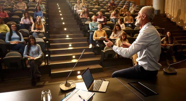 IVA: edición y publicación de artículos divulgativos en internet elaborados por profesores e investigadores Análisis de la sujeción al IVA de los ingresos de una asociación sin ánimo de lucro reconocida como entidad de utilidad pública en relación con sus actividades de edición y publicación de artículos divulgativos y los convenios de colaboración con entidades externas. Imagen de un profesor dando clase en la universidad