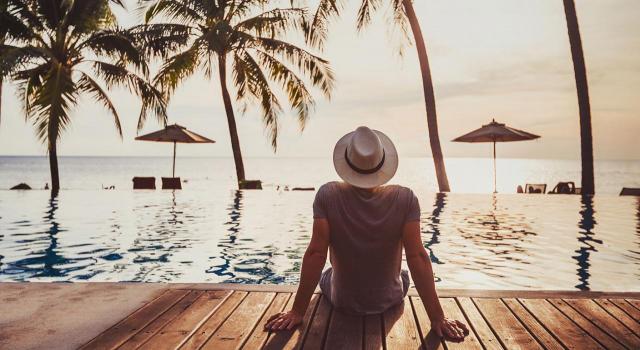 Proyecto de orden que aprueba la lista de jurisdicciones no cooperativas. Imagen de un chico en turismo relax en un hotel de playa de lujo mirando al mar