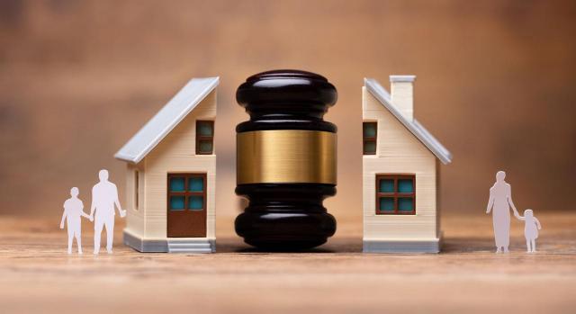 EL TS establece los requisitos para aplicar la exención por reinversión de la vivienda habitual por cónyuges separados o divorciados. Imagen de mazo de justicia entre familiares y hogar