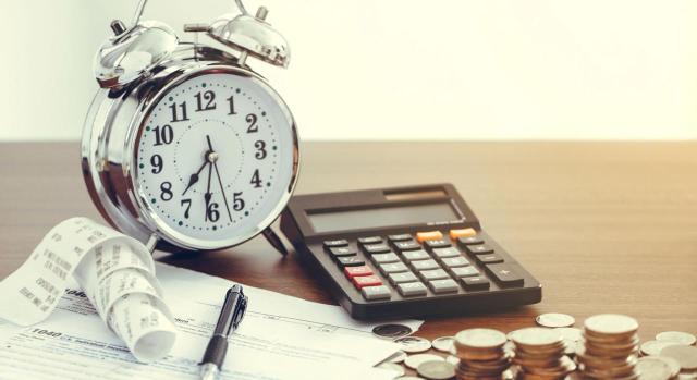 ¿En qué ejercicio debe aplicarse la deducción en el IS del deterioro de un crédito a una entidad vinculada declarada en concurso? El TS debe determinar en qué ejercicio debe aplicarse la deducción en el IS del deterioro de un crédito a una entidad vinculada declarada en concurso, contabilizado en una cuenta de pérdidas y ganancias o de reservas. Imagen de un reloj y una calculadora junto a facturas y dinero