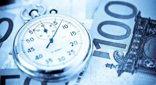 TS, deducicilidad, IS, intereses de demora. Un reloj sobre un billete de 100 euros