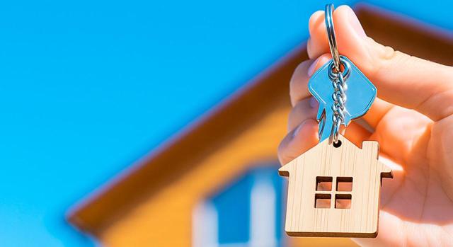 Arrendador que cede el derecho de cobro a una empresa. Vivienda en segundo plano y mano con llaves