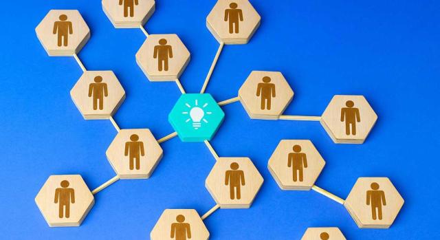 Retribuciones en especie en operaciones vinculadas Calificación de servicios personalísimos, aplicación del método de precio libre comparable y la valoración de retribuciones en especie. Imagen de hexagonos de madera con la figura de una persona que salen de una pieza central azul
