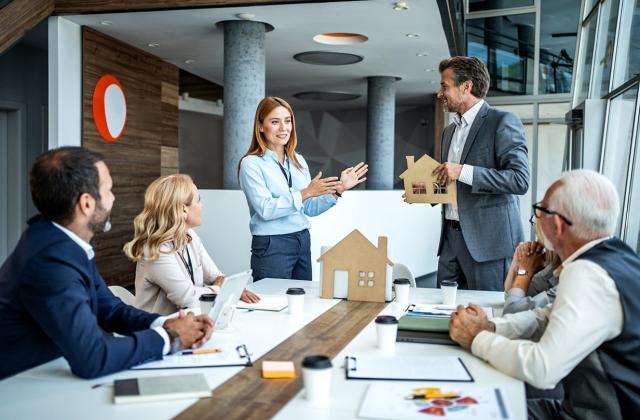 Reducción del 95% ISD por la donación de participaciones a la que se aplica la exención IP: persona a jornada completa contratada por otra sociedad del grupo, y no por la arrendadora, para gestionar la actividad de arrendamiento del grupo. Imagen de una reunión sobre inmobiliario