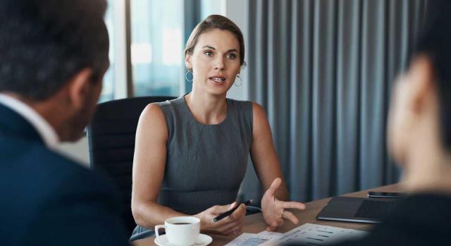 Deducción en el IRPF de los gastos de la vivienda alquilada afecta parcialmente a la actividad profesional de abogado a pesar de no haberla sujetado a IVA. Imagen de una reunión de trabajo en el que la mujer lleva la voz cantante
