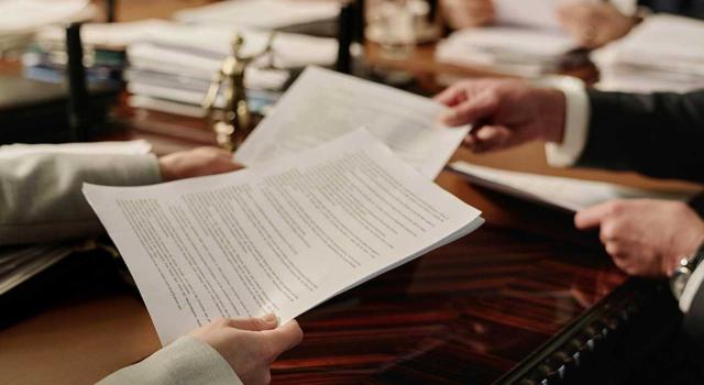 Una autoliquidación no es un acto administrativo que admita revisión de oficio por nulidad de pleno derecho Una autoliquidación, transcurrido el plazo de prescripción sin actuación administrativa, no puede ser considerada acto administrativo a efectos de la revisión de oficio por nulidad de pleno derecho. Imagen de las manos de una mujer entregando unos documentos
