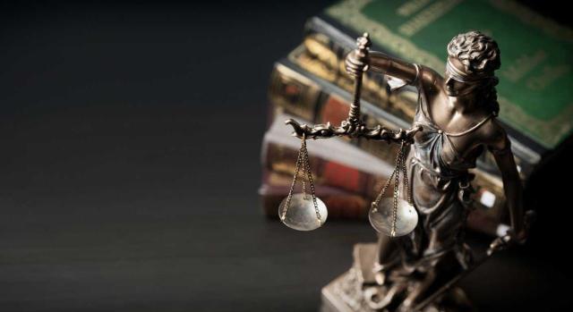 Selección de jurisprudencia. Primera quincena de noviembre de 2025. Imagen de la señora de la justicia sobre unos libros en una biblioteca