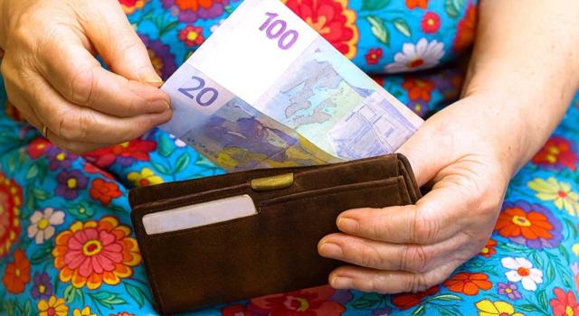 Determinación del número de pagadores en el ámbito de las Administraciones Públicas a efectos de determinar el límite de rendimientos del trabajo a efectos de la obligación de presentar declaración en el IRPF. Imagen de una mujero sacando dinero de su cartera