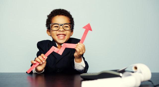 Proyectos de ley de impuestos sobre servicios digitales y transacciones financieras. Niño trajeado sonriendo y con una flecha económica en la mano