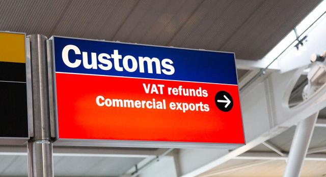 Modificaciones de la Directiva IVA para que los proveedores o sujetos pasivos no establecidos en la Unión que no utilicen el régimen IOSS designen un representante fiscal que asuma todas las obligaciones en materia de IVA. Imagen de  un cartel  de aduanas en un aeropuerto