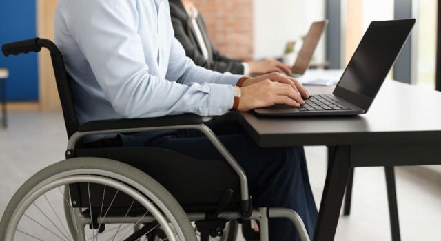 Deducción por trabajador activo con discapacidad: reconocimiento durante el ejercicio Aplicación de la deducción por trabajador activo con discapacidad cuando el reconocimiento se produce durante el ejercicio fiscal. Imagen de un chico en silla de ruedas trabajando con su portátil