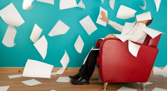 La AN estima desproporcionado el archivo de actuaciones por un defecto formal en la representación del obligado tributario que había sido validado por la propia Administración en todas las actuaciones anteriores. Imagen de un hombre sentado en un sillón rojo tirando al aire folios en blanco