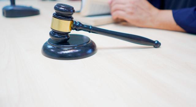 Devengo del ITP en la transmisión de un bien inmueble mediante subasta judicial. Juez leyendo la decisión y mazo judicial