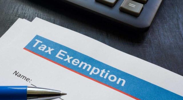 Exención fiscal de cánones con efectos retroactivos sobre períodos anteriores. Imagen de un documento Tax Exemption con un boli y un teclado de ordenador