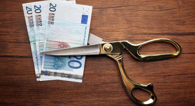 Se exigen al retenedor las retenciones no practicadas sin necesidad de regularización previa de los perceptores. Imagen de unas tijeras queriendo cortar tres billetes de 20 euros