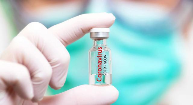 Vacunas contra la COVID-19. Médico con guantes sosteniendo vacuna contra Covid 19
