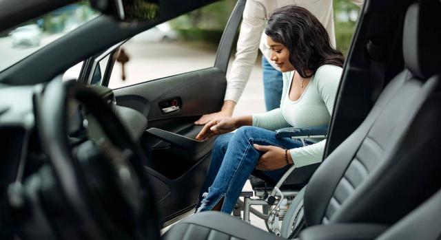 Tipo IVA: vehículo para personas con movilidad reducida comprado en la UE. Joven discapacitada subiendo a un coche