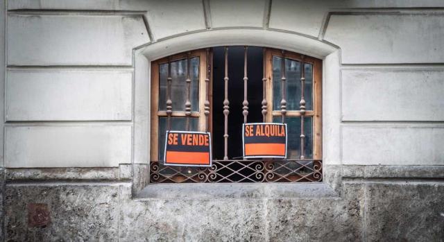 Las operaciones de extinción de condominio en las que no se den excesos de adjudicación tributan por la modalidad de AJD. Imagen de una ventana de un edificio con los carteles de se vende y se alquila